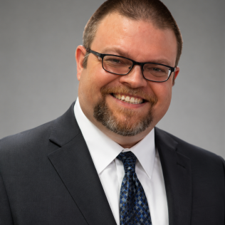 Image of dave in a suit against a grey background