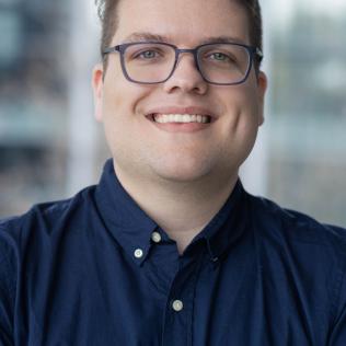 Image of Mike in blue shirt in front of a blurred background.